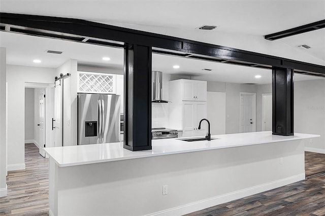 505 Lake Shore Dr, Maitland, FL 32751 - kitchen with wood finished floors, a sink, stainless steel appliances, white cabinets, and wall chimney exhaust hood