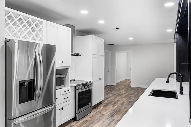 505 Lake Shore Dr, Maitland, FL 32751 - kitchen featuring white cabinets, a sink, wall chimney range hood, light countertops, and appliances with stainless steel finishes