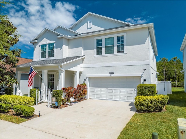 view of front facade featuring a garage, stucco siding, concrete driveway, and a front lawn