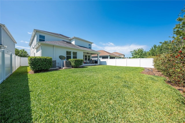rear view of property with a fenced backyard, stucco siding, a lawn, a patio, and central AC unit