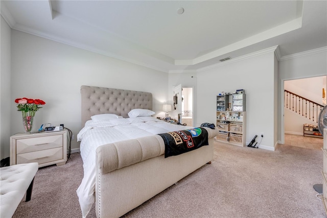 carpeted bedroom with ornamental molding, visible vents, baseboards, and a raised ceiling