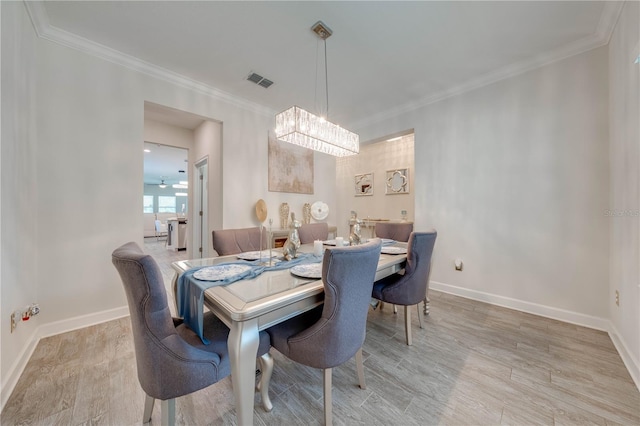 dining space featuring an inviting chandelier, baseboards, ornamental molding, and visible vents