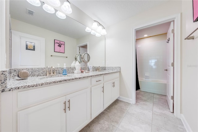 full bathroom featuring a sink, visible vents, tile patterned floors, and double vanity