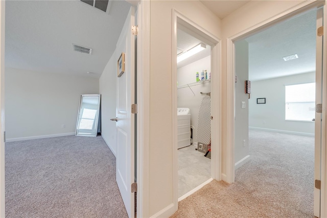 corridor with a wealth of natural light, carpet flooring, and visible vents