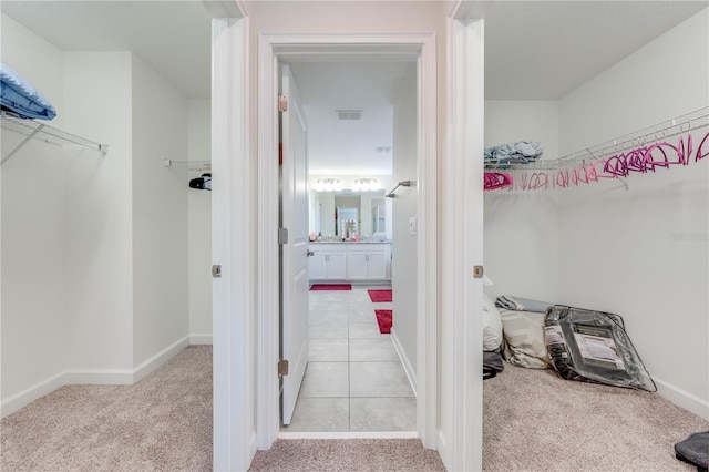 walk in closet with visible vents and light colored carpet