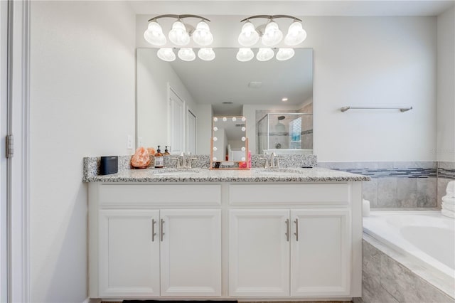 bathroom featuring a sink, a shower stall, double vanity, and a garden tub