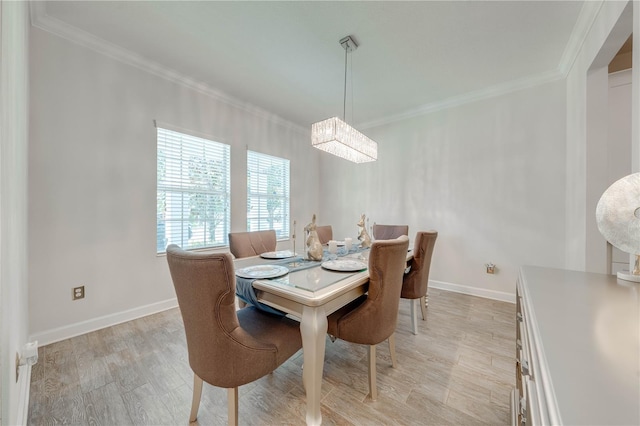 dining area with light wood-type flooring, a notable chandelier, baseboards, and ornamental molding