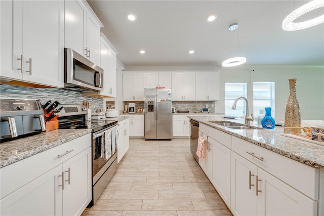 kitchen featuring a sink, appliances with stainless steel finishes, recessed lighting, white cabinetry, and backsplash