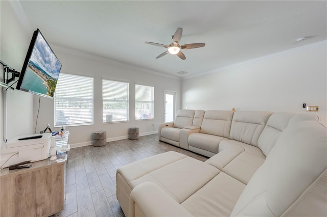 living room featuring ornamental molding, light wood-style flooring, a ceiling fan, and baseboards