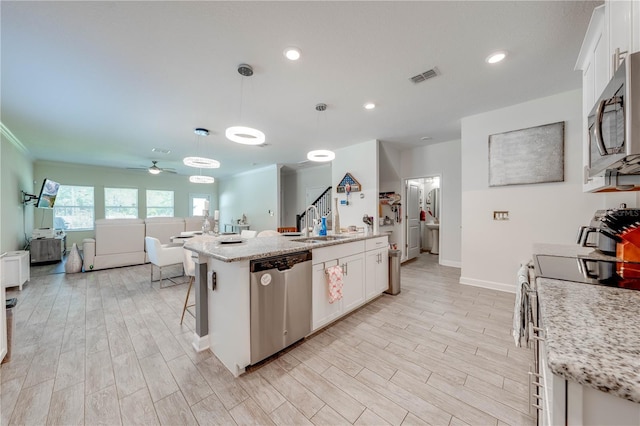 kitchen featuring open floor plan, a ceiling fan, visible vents, stainless steel appliances, and light wood finished floors