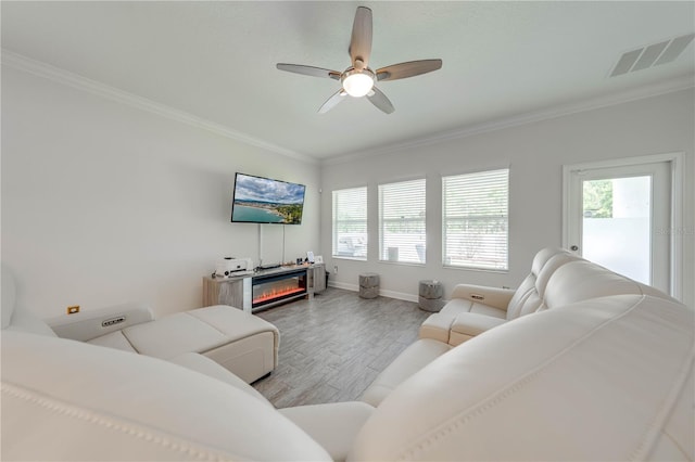 living room featuring visible vents, crown molding, a ceiling fan, and wood finished floors