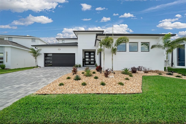 10549 Torchwood Sea Way, San Antonio, FL 33576 - modern home featuring stucco siding, a garage, a front yard, and decorative driveway
