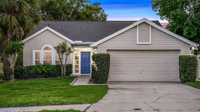 1027 Dees Dr, Oviedo, FL 32765 - ranch-style house with concrete driveway, a garage, a front lawn, roof with shingles, and stucco siding