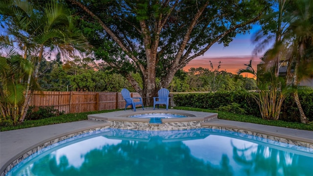 1027 Dees Dr, Oviedo, FL 32765 - pool at dusk featuring an in-ground hot tub