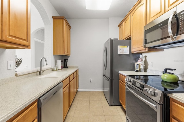 8296 Portofino Dr Unit 405, Davenport, FL 33896 - kitchen with baseboards, arched walkways, a sink, light countertops, and appliances with stainless steel finishes