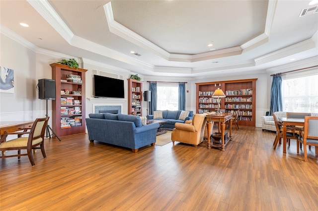 8296 Portofino Dr Unit 405, Davenport, FL 33896 - living area featuring a fireplace, a tray ceiling, crown molding, and wood finished floors