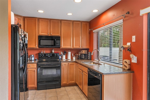 kitchen featuring stone counters, recessed lighting, light tile patterned flooring, black appliances, and a sink