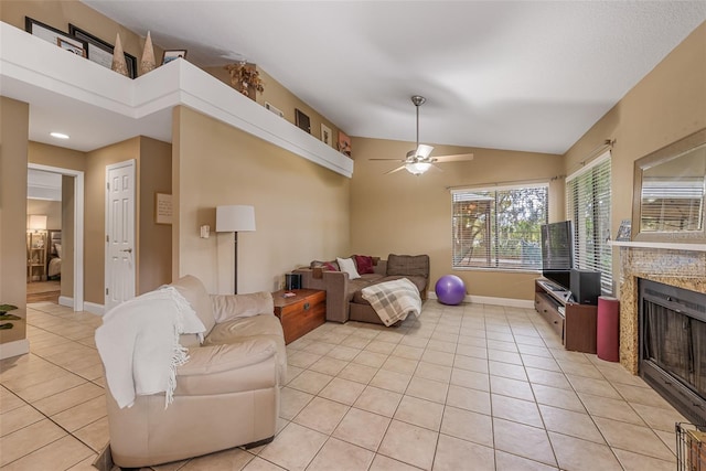 living area featuring light tile patterned floors, baseboards, a ceiling fan, a fireplace, and lofted ceiling