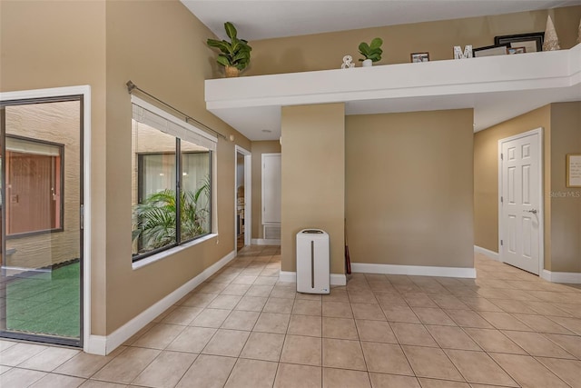 interior space with light tile patterned floors and baseboards