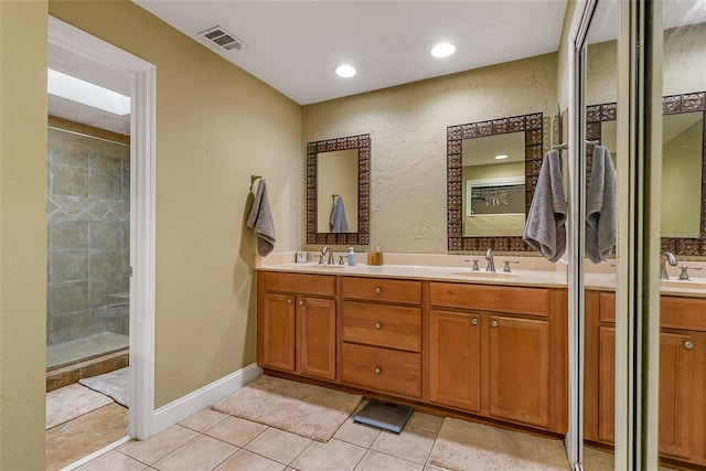 full bath featuring tile patterned flooring, double vanity, a sink, and a stall shower
