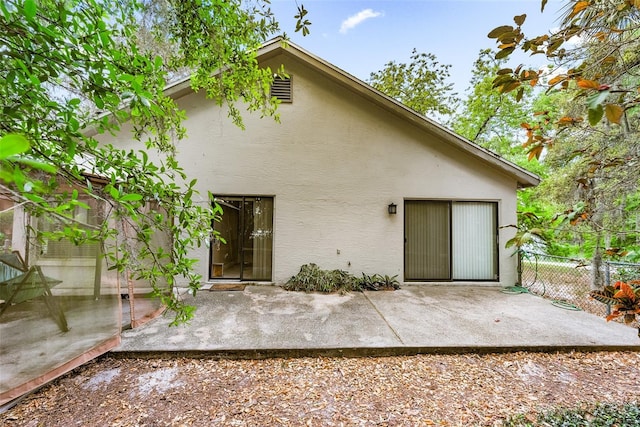 back of property featuring a patio, stucco siding, and fence