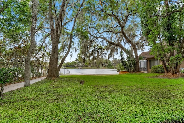 view of yard with fence and a water view