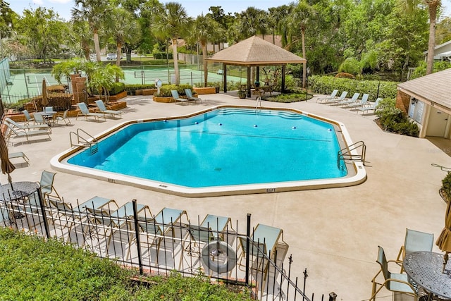 community pool featuring a gazebo, a patio area, and fence