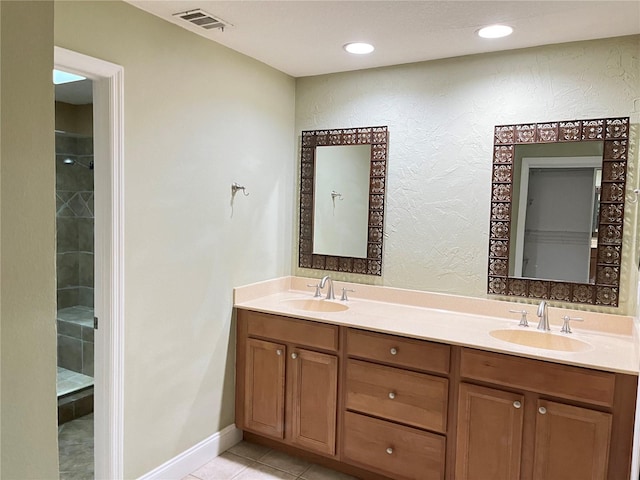 600 Fallsmead Cir, Longwood, FL 32750 - bathroom with double vanity, tile patterned flooring, a tile shower, and a textured wall