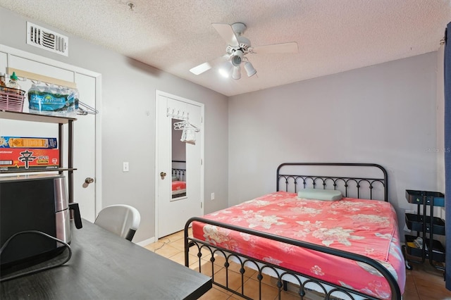 3921 SW 34th St Unit 102, Gainesville, FL 32608 - bedroom featuring light tile patterned flooring, a textured ceiling, and a ceiling fan