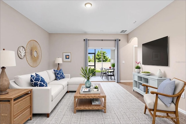 living room featuring baseboards, visible vents, and light wood-type flooring