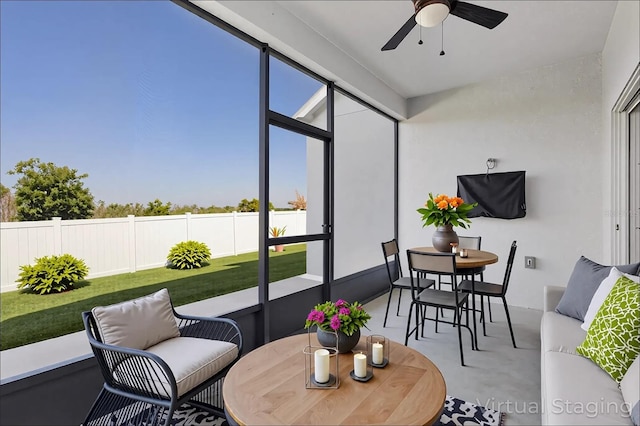sunroom / solarium with a ceiling fan and outdoor dining area