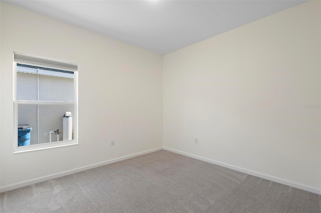 carpeted empty room with baseboards