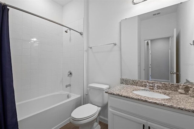 bathroom with visible vents, wood finished floors, vanity, toilet, and shower / bathtub combination with curtain
