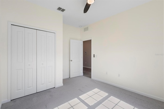 unfurnished bedroom featuring baseboards, light carpet, a closet, and visible vents