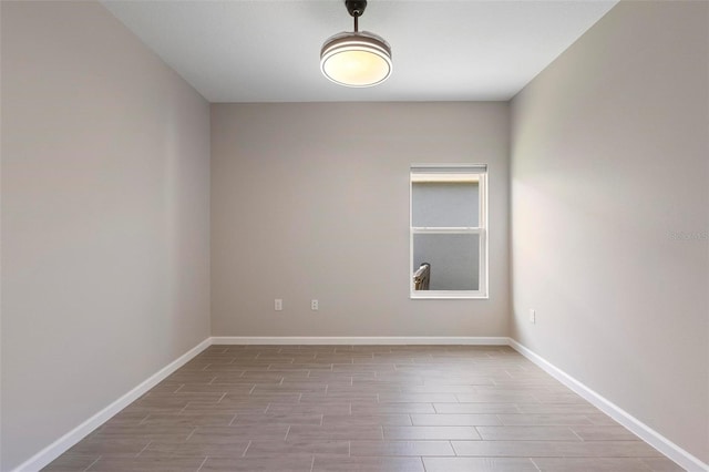 spare room featuring baseboards and wood finished floors