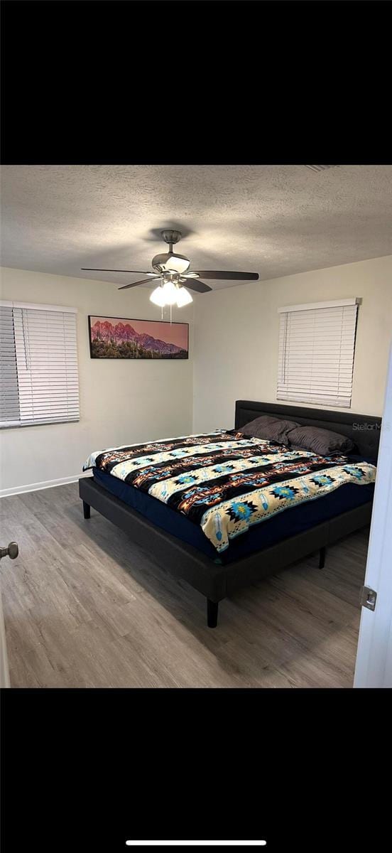 2902 Little Rd, Valrico, FL 33596 - bedroom featuring ceiling fan, wood finished floors, and a textured ceiling