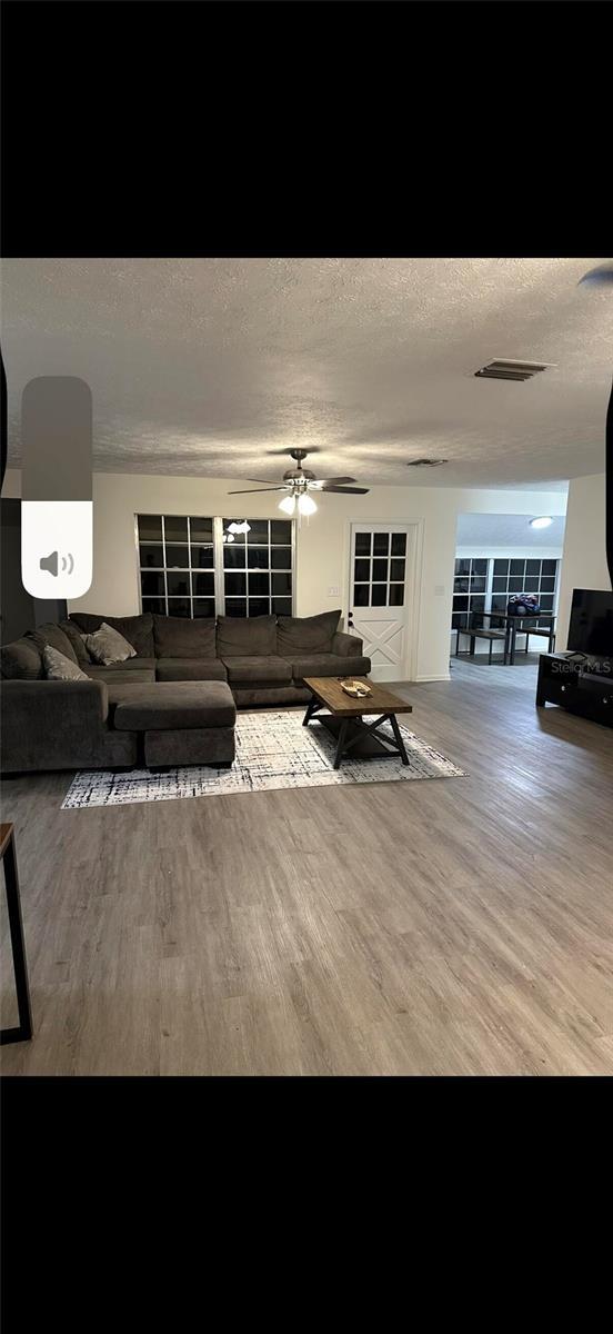 2902 Little Rd, Valrico, FL 33596 - living room with visible vents, a textured ceiling, and wood finished floors