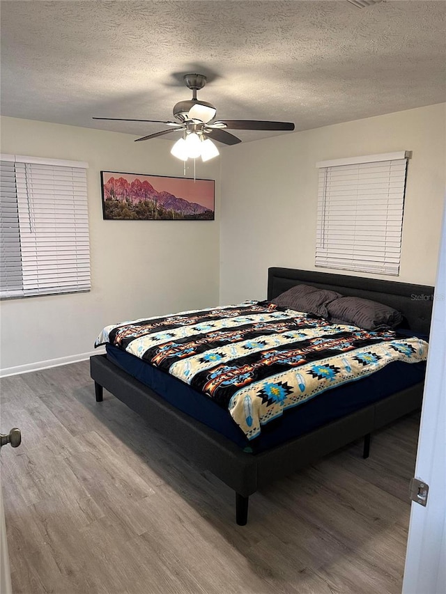 2902 Little Rd, Valrico, FL 33596 - bedroom with baseboards, a textured ceiling, a ceiling fan, and wood finished floors