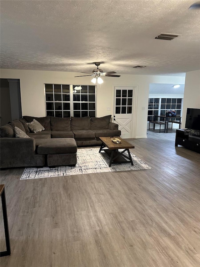 2902 Little Rd, Valrico, FL 33596 - living room with ceiling fan, visible vents, a textured ceiling, and wood finished floors