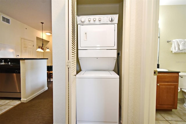 8112 Poinciana Blvd Unit 1809, Orlando, FL 32821 - washroom featuring stacked washer and dryer, visible vents, light tile patterned flooring, a notable chandelier, and laundry area