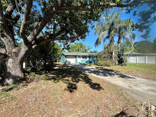 view of front of house with fence, a garage, and driveway