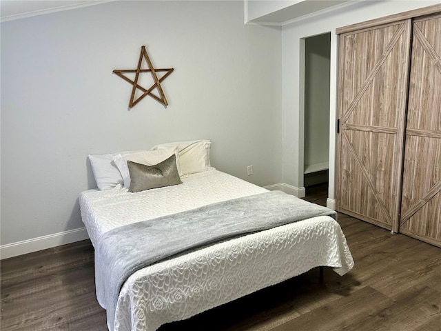 bedroom with dark wood-type flooring and baseboards