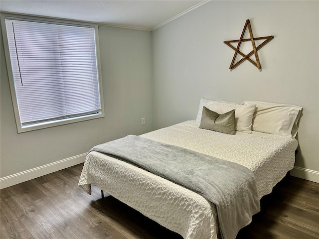 bedroom featuring baseboards, crown molding, and wood finished floors