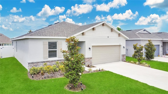 ranch-style house with an attached garage, a front yard, stone siding, and concrete driveway