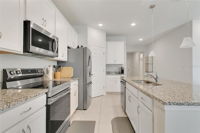 kitchen featuring white cabinetry, appliances with stainless steel finishes, light tile patterned floors, and a center island with sink