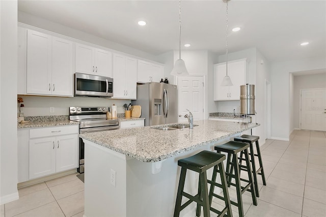 kitchen featuring baseboards, a sink, light tile patterned floors, and stainless steel appliances