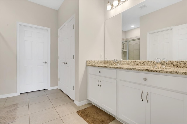 full bath with tile patterned flooring, a sink, baseboards, and a shower stall