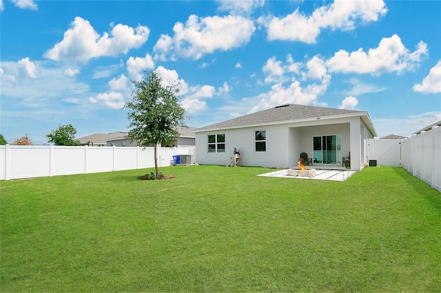 back of house featuring central AC, stucco siding, a fenced backyard, a patio, and a yard