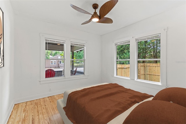 bedroom featuring baseboards, ceiling fan, and light wood finished floors