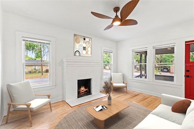 living room with a healthy amount of sunlight, a fireplace, and wood finished floors
